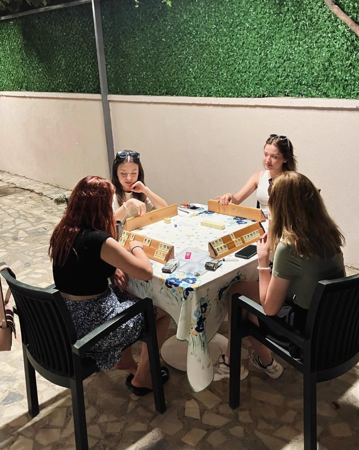 Genç misafirler terasta okey oynuyor